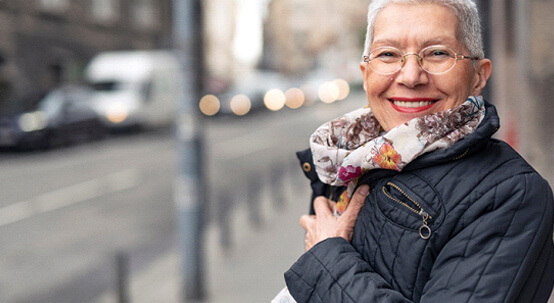 A beautiful senior woman smiling outdoors while wearing a jacket