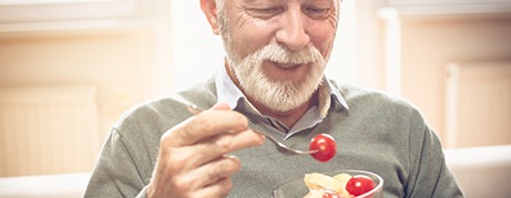 Patient in Commack eating with dentures