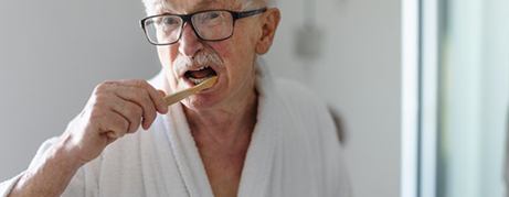 Patient in Commack brushing their dentures