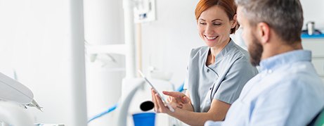 Dentist reviewing information with smiling patient