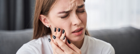 Woman holding her cheek in pain