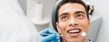 A cheerful man receiving a dental checkup 
