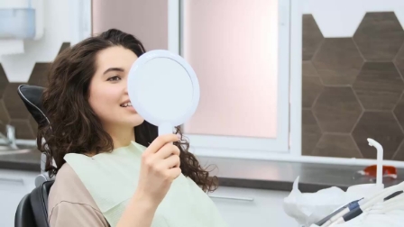 Dental patient looking at her smile in a mirror