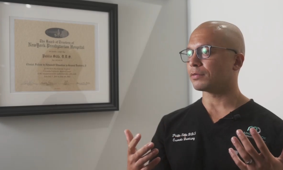 Doctor Silfa talking with framed diploma on wall in background