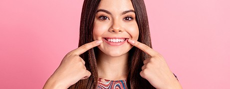 Woman pointing to her smile