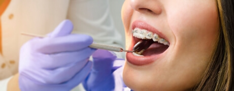 Young woman with braces receiving a dental exam