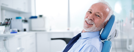 Smiling senior man leaning back in dental chair