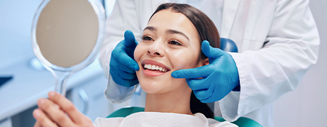 Dental patient admiring her smile in mirror