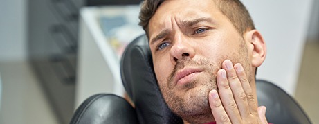 Patient with toothache sitting in treatment chair
