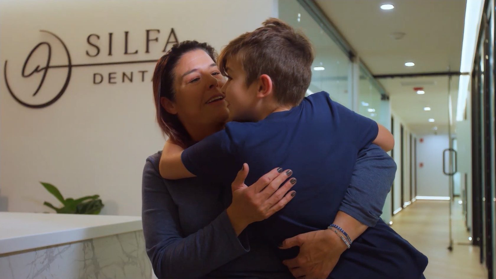 Salina hugging her son in the Silfa Dental office