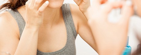 Woman putting on teeth whitening strip at home