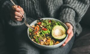 Woman with colorful bowl of salad on her lap